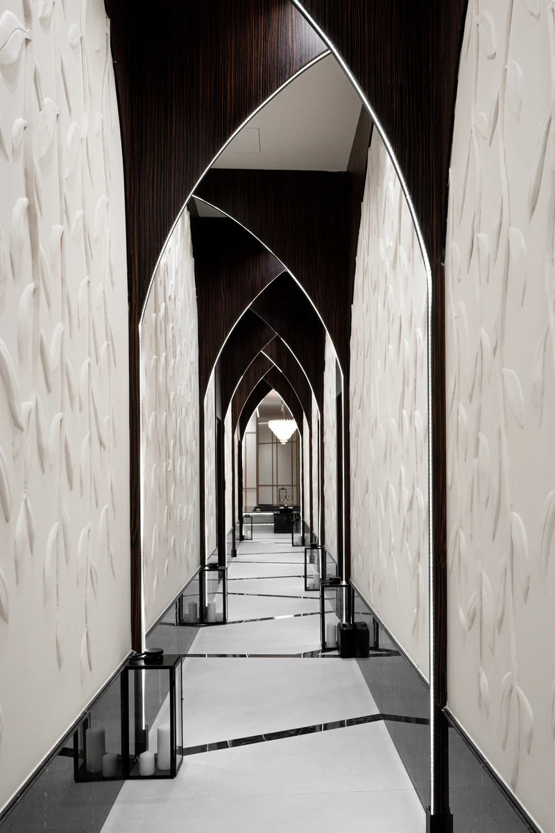 A corridor with pointed arches and mirrors