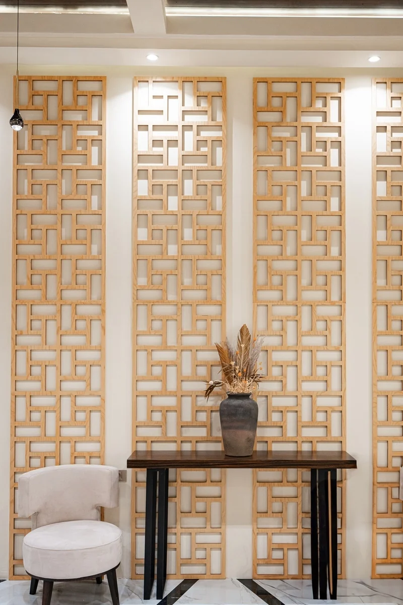 A lattice panel with a console and a vase